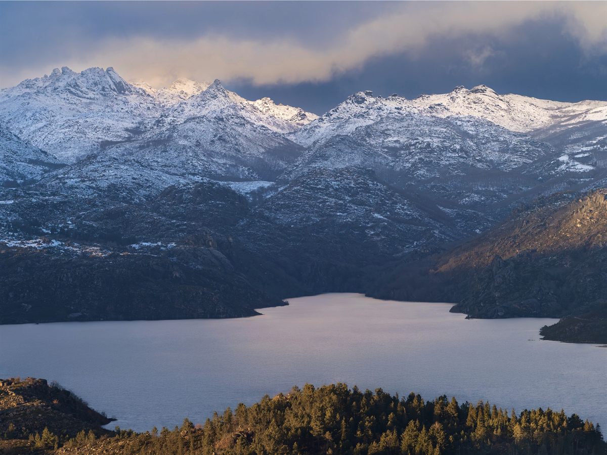 Serras com neve sobre a albufeira no Parque Nacional da Peneda-Gerês
