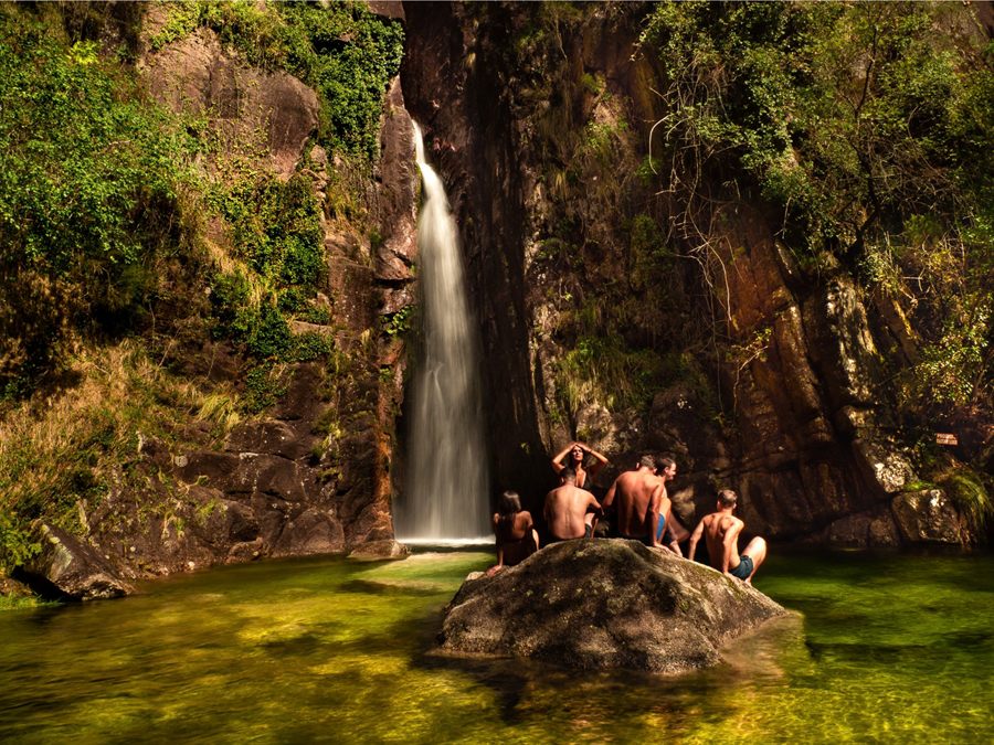 Swimmers by a waterfall in summer in Peneda-Gerês National Park