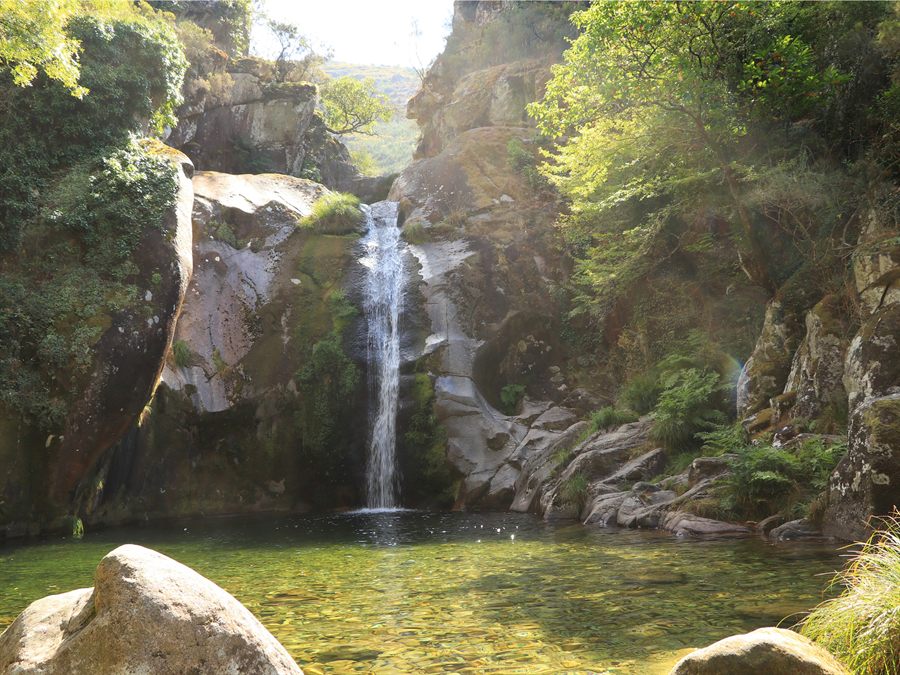 Waterfall and sunlit pool in Peneda-Gerês National Park