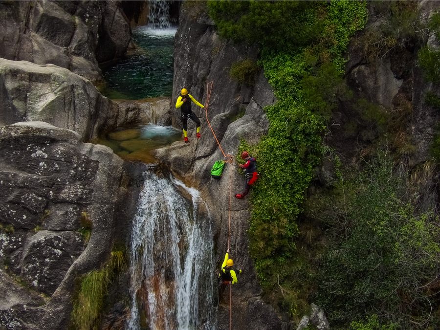 Groupe faisant du canyoning dans une gorge avec cascade dans le Parc National de Peneda-Gerês